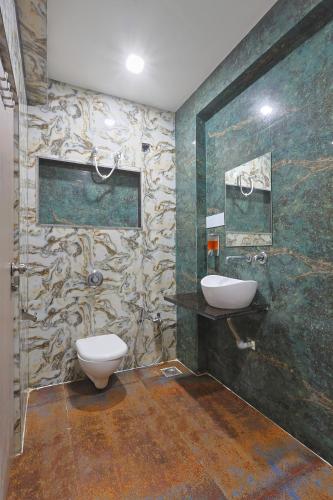 a bathroom with a toilet and a sink at Hotel Lord Krishna Dham in Dwarka