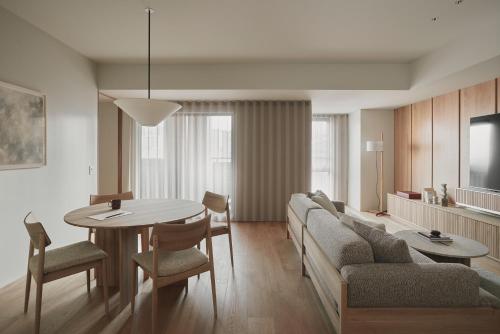 a living room with a table and a couch at TOMI Ginza in Tokyo