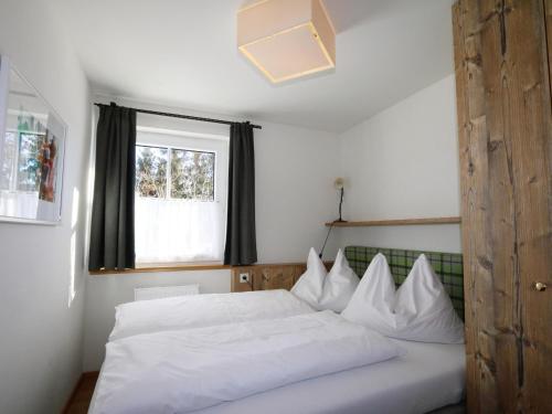 a bedroom with a white bed and a window at Vacation home in Flachau in Flachau