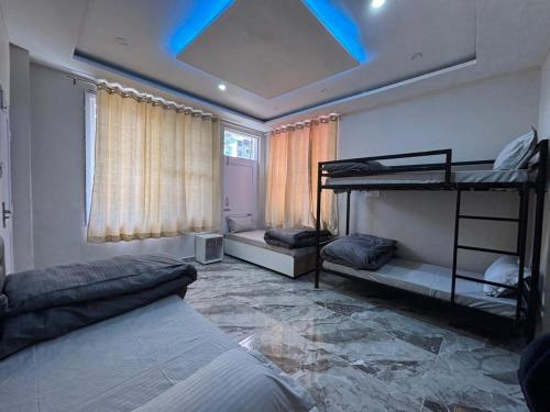 a bedroom with two bunk beds and a blue ceiling at ZuZu Hostels Mcleodganj in Dharamshala