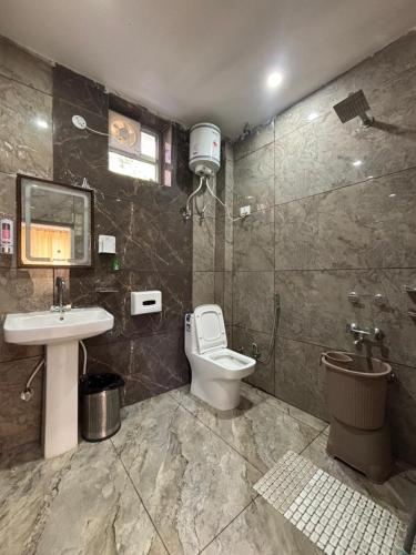 a bathroom with a toilet and a sink and a shower at ZuZu Hostels Mcleodganj in Dharamshala
