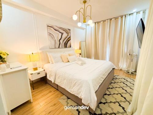 a bedroom with a bed and a desk and a window at White Villa in General Santos