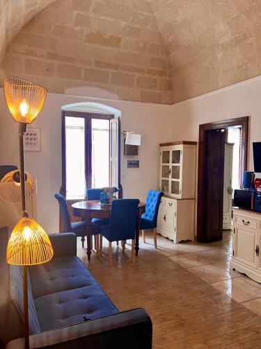 a living room with a table and blue chairs at Le Dimore al Castello in Massafra