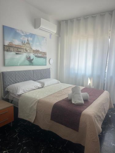 a bedroom with a bed with a painting on the wall at stazione Lina house in Mestre