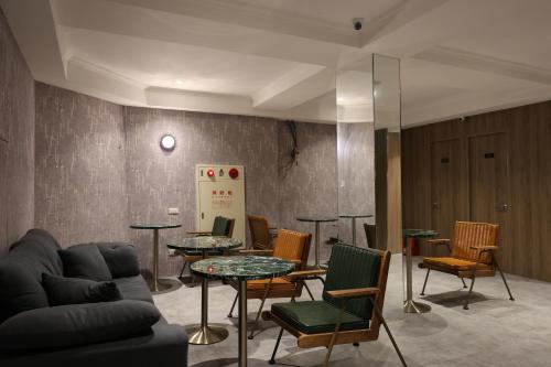 a living room with a couch and tables and chairs at Fun Stay Inn Hanzhong in Taipei