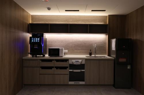 a kitchen with a sink and a refrigerator at Fun Stay Inn Hanzhong in Taipei