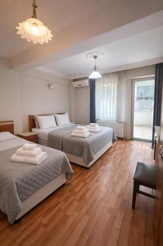a bedroom with two beds and a chandelier at Coskun Otel Şarköy in Şarköy