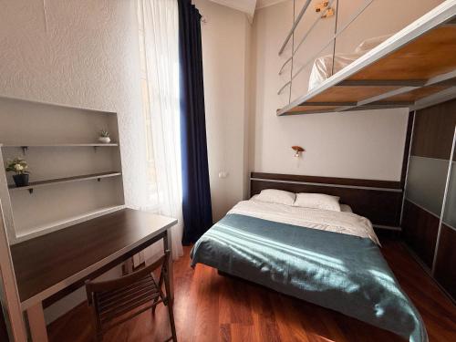 a small bedroom with a bed and a desk at Kyiv Muse Apartment in Kyiv
