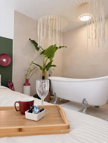 a bathroom with a bath tub and a sink at La Suite Bohème Émeraude in Évreux