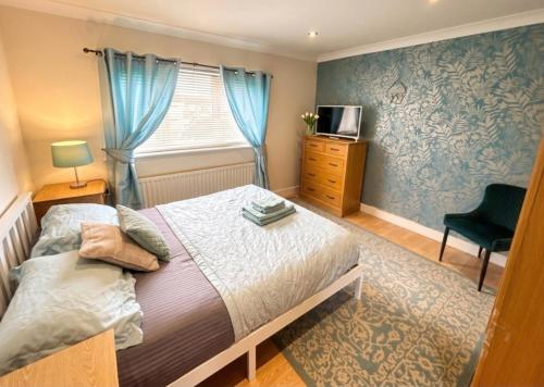 a bedroom with a bed and a window and a chair at 2 Bed House - Sleeps 4 - Parking - Pets - Garden in Doncaster