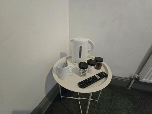 a small table with a coffee pot and a remote control at Church Views in Burnley
