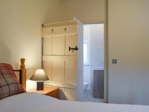 a bedroom with a bed and a bathroom with a tub at Richmond Cottage in Ashby Saint Ledgers
