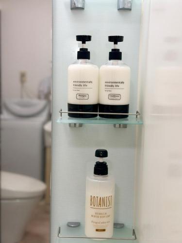 a refrigerator with three bottles of soap and a toilet at Mori de house in kobe 302 in Kobe
