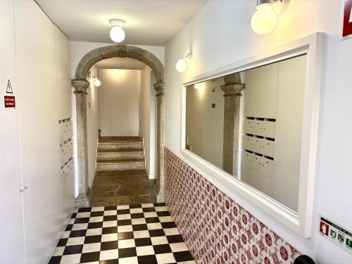 a hallway with a checkered floor and a mirror at Alfama Premium in Lisbon