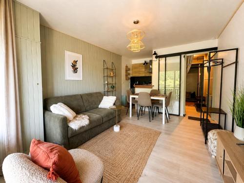 a living room with a couch and a dining room at Lodge Montëva - Le Chinaillon - Au pied des pistes in Le Grand-Bornand