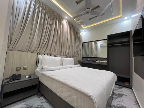 a bedroom with a large bed with a ceiling fan at Heritage Heaven by Premium Suites in Karachi