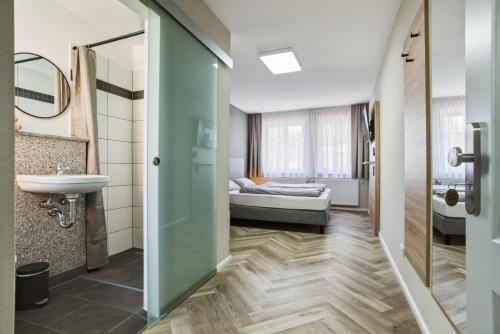 a bathroom with a sink and a bed in a room at Altstadt Pension Vlotho in Vlotho