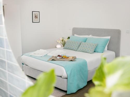 a bedroom with a bed with blue pillows at Quinta Cerca da Milhera in Ponte da Barca
