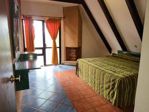 a bedroom with a bed and a door with a window at Turinjandi in Zirahuén