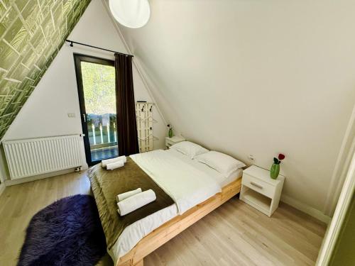 a small bedroom with a bed and a window at Cabana Doinița in Borşa