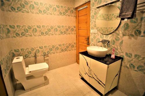 a bathroom with a toilet and a sink at Mountainshack Riverside Stay & Cafe in Kulu
