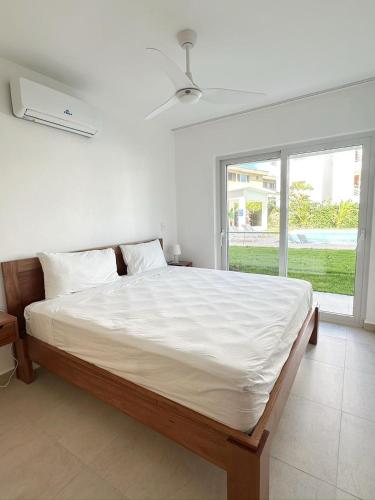 a bedroom with a large white bed and a window at Mananero Group Residence in Cabarete