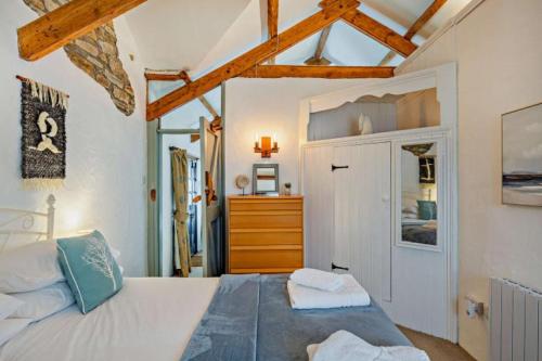 a bedroom with a bed and a dresser at Cobble Cottage in Cardinham
