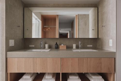 a bathroom with two sinks and a large mirror at TOMI Ginza in Tokyo