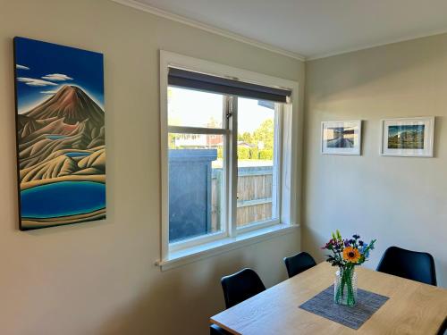 a dining room with a table and a window at Hanmer Time in Hanmer Springs