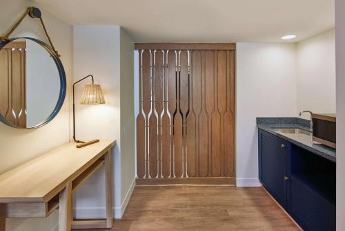 a bathroom with a mirror and a wooden closet at OUTRIGGER Reef Waikiki Beach Resort in Honolulu