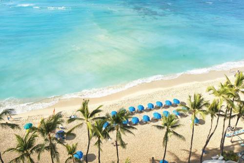 an aerial view of a beach with palm trees and umbrellas at OUTRIGGER Waikiki Beach Resort in Honolulu