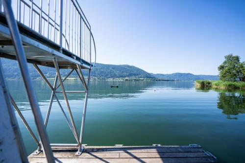eine Brücke über ein großes Gewässer in der Unterkunft Seehotel Hoffmann in Steindorf am Ossiacher See