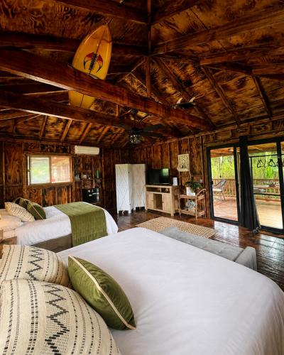 a bedroom with three beds in a room with wooden ceilings at Pipeline Tropical Bungalow in Haleiwa