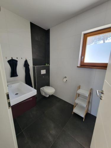 a bathroom with a sink and a toilet and a window at Heideberg Appartement in Zeuthen