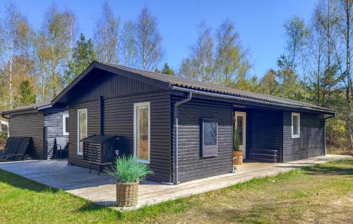 a small black house with a porch and a deck at Gorgeous Home In Læsø With Wifi in Læsø