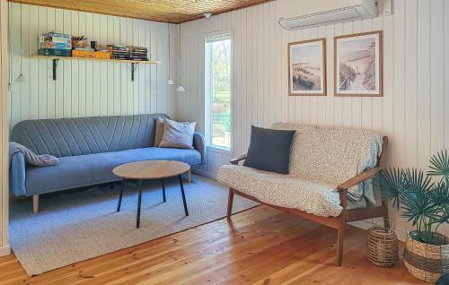 a living room with a blue couch and a chair at Gorgeous Home In Læsø With Wifi in Læsø