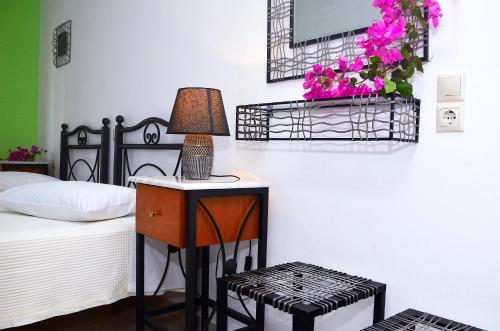 a bedroom with a bed and a table with a lamp at Onar Studios in Koufonisia