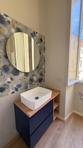 a bathroom with a white sink and a mirror at Dimora del Loggiato in Acqui Terme