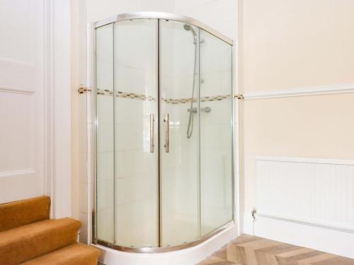 a glass shower in a bathroom with stairs at Dowrich West Wing Apartment in Crediton