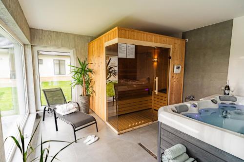 a bathroom with a tub and a chair in it at Vila Diamond Lux&Spa in Sovata