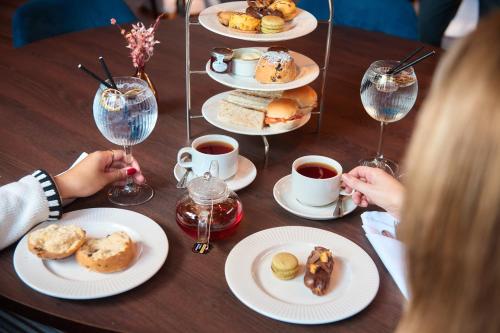 a table with plates of pastries and cups of coffee at Delta Hotels by Marriott Preston in Preston