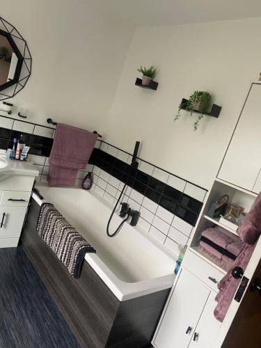 a bathroom with a bath tub and a sink at Butterfly House in Blackwood