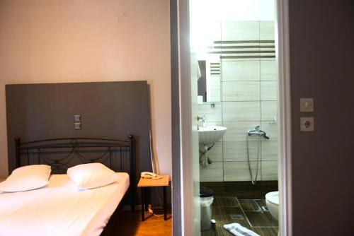 a bedroom with a bed and a bathroom with a shower at Electra Hotel Piraeus in Piraeus