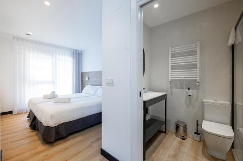 a bedroom with a bed and a sink and a toilet at Donosti rooms in Loyola