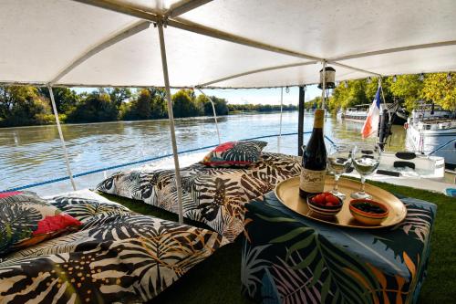 a table with a bottle of wine and glasses on a boat at Péniche Le Makara in Avignon