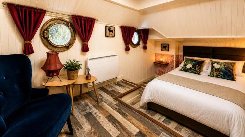 a bedroom with a bed and a chair and a table at Péniche Le Makara in Avignon