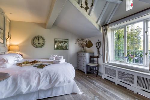 a bedroom with a bed and a clock on the wall at Apple Cottage in Snowshill