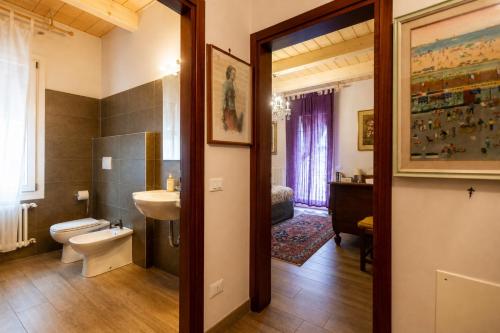 a bathroom with a toilet and a sink and a mirror at Al Battistero Luxury Suite in Ravenna