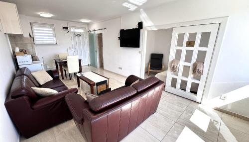 a living room with a couch and a table at Rest House Apartman in Nyíregyháza