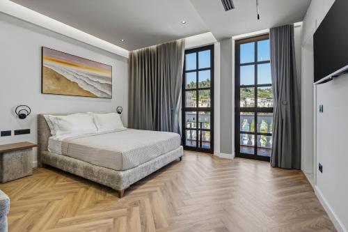a bedroom with a bed and two windows at Art Boutique Hotel Berat in Berat
